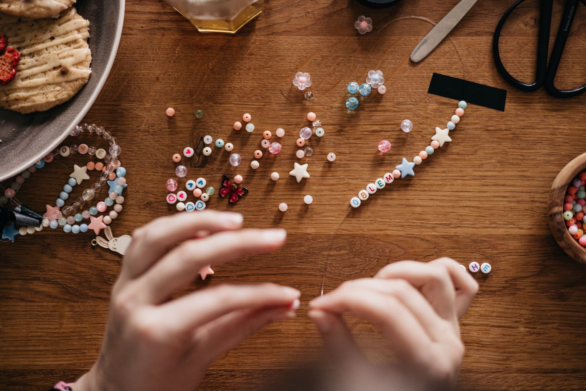 person placing beads on string