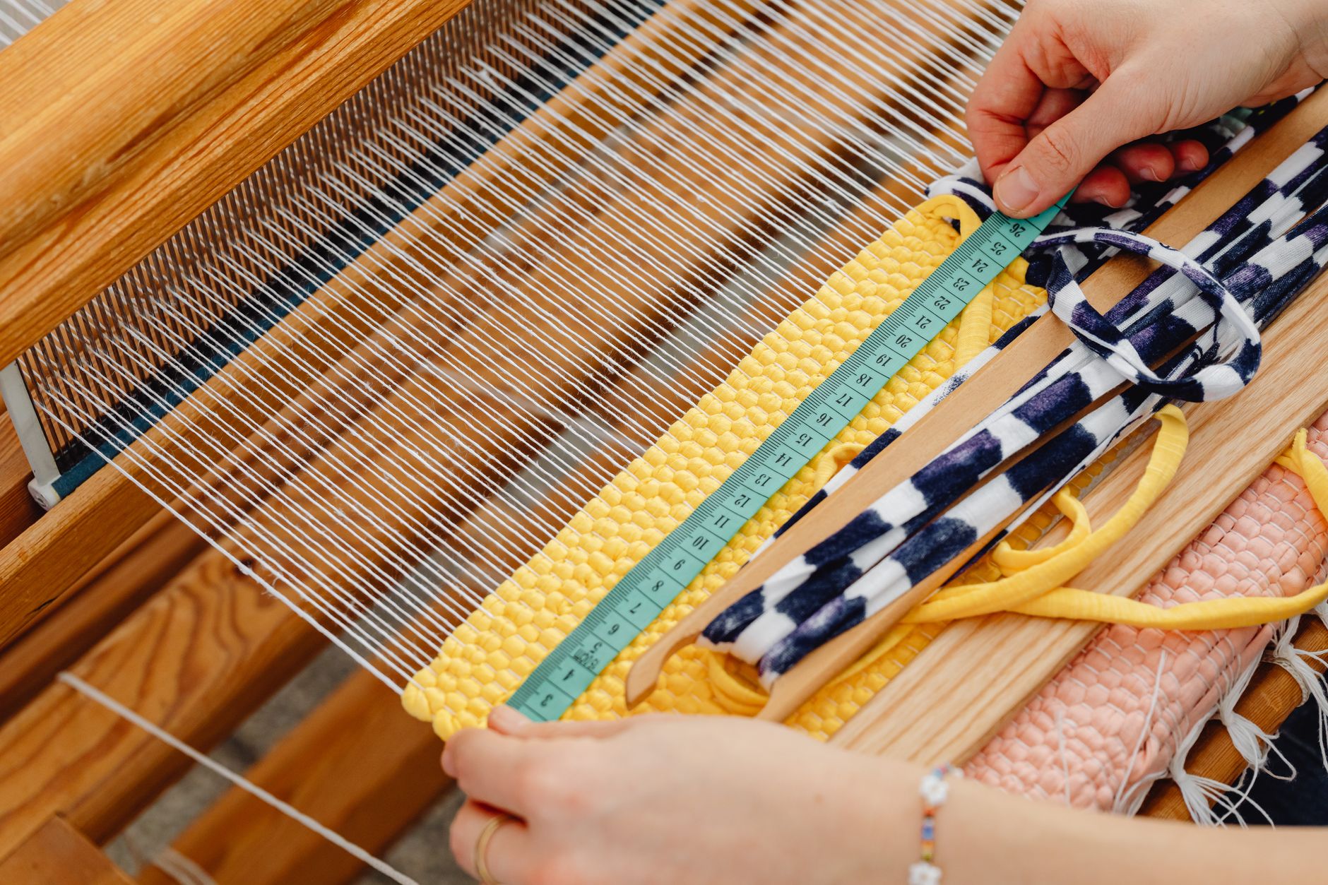 woman measuring the weave on a loom
