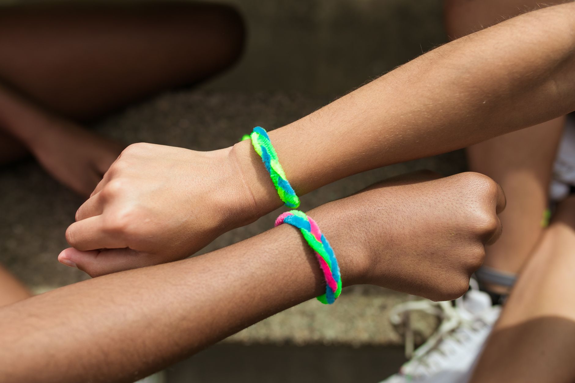 close up shot of two people wearing colorful bracelets
